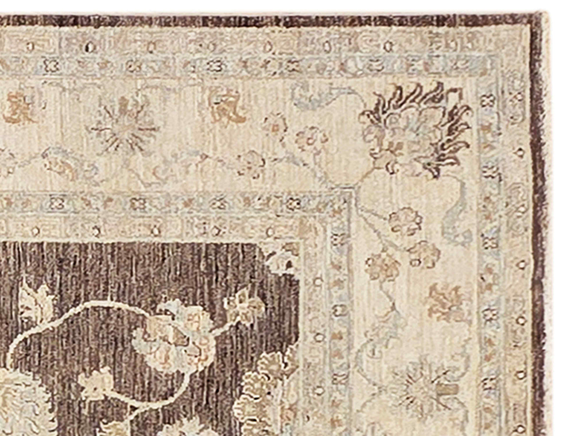 Close-up of beige Afghan rug border with floral motifs and dark accents