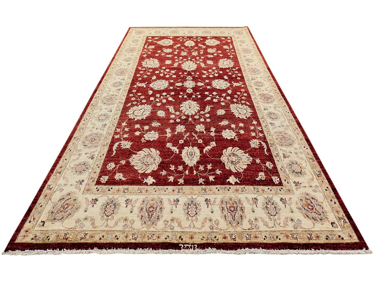 Red rug with cream center panel, ornate floral design, bordered edges