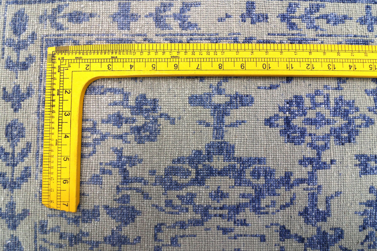 Blue mist rug close-up with distressed pattern; yellow measuring tape on the surface.