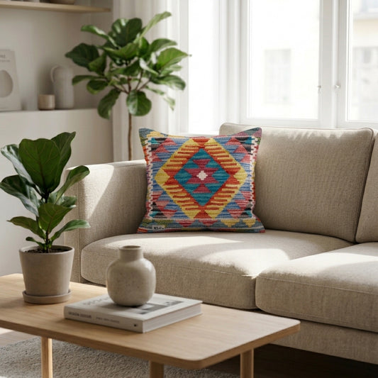 Square kilim cushion with multicolor geometric diamond pattern on a sofa