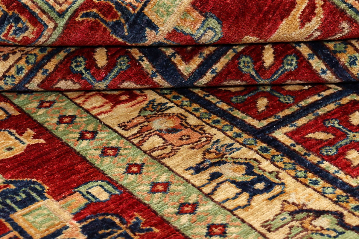 Close-up rug texture with red, blue, and beige geometric bands and motifs