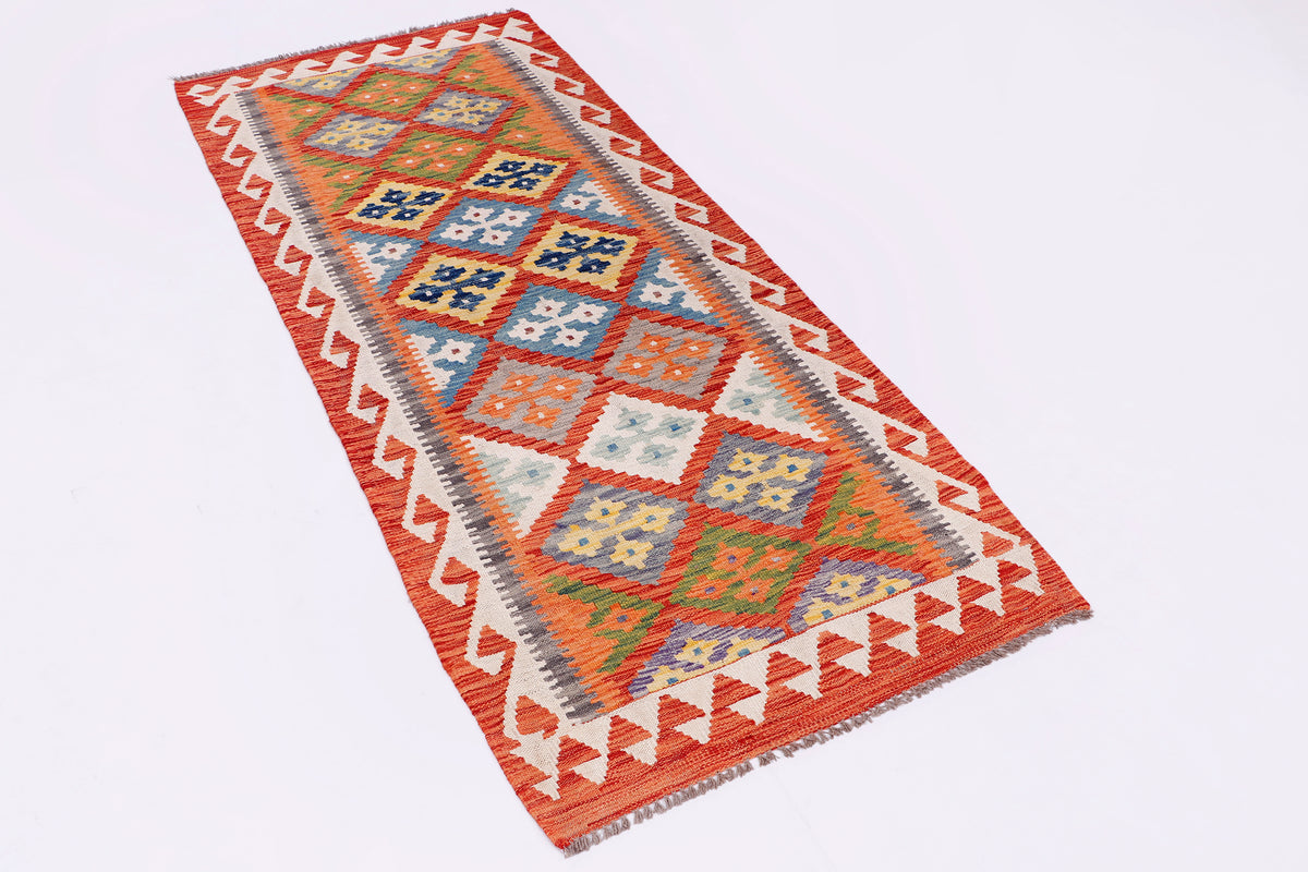 Orange kilim rug, patterned border and geometric motifs, overhand fold view