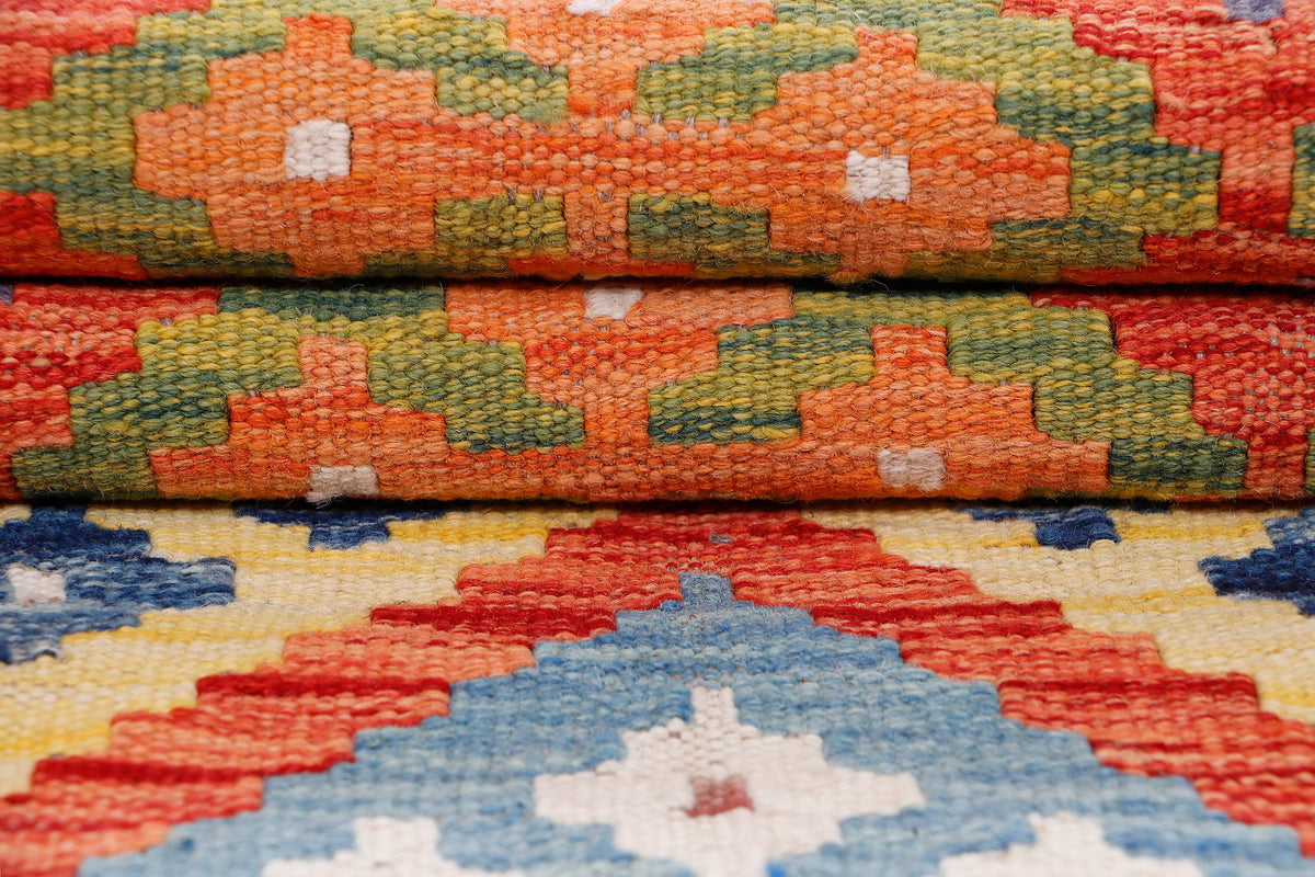Orange kilim rug texture close-up with layered geometric bands and fringe