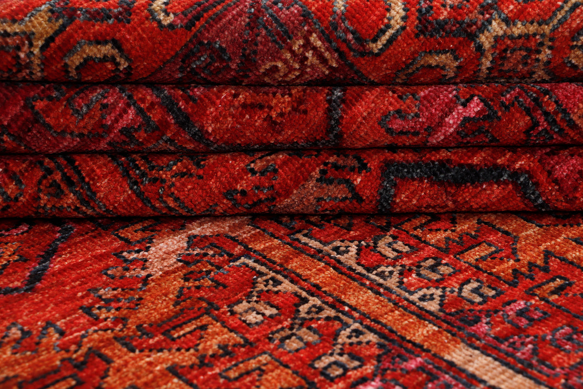 Red patterned rug with medallion and geometric border, close-up texture