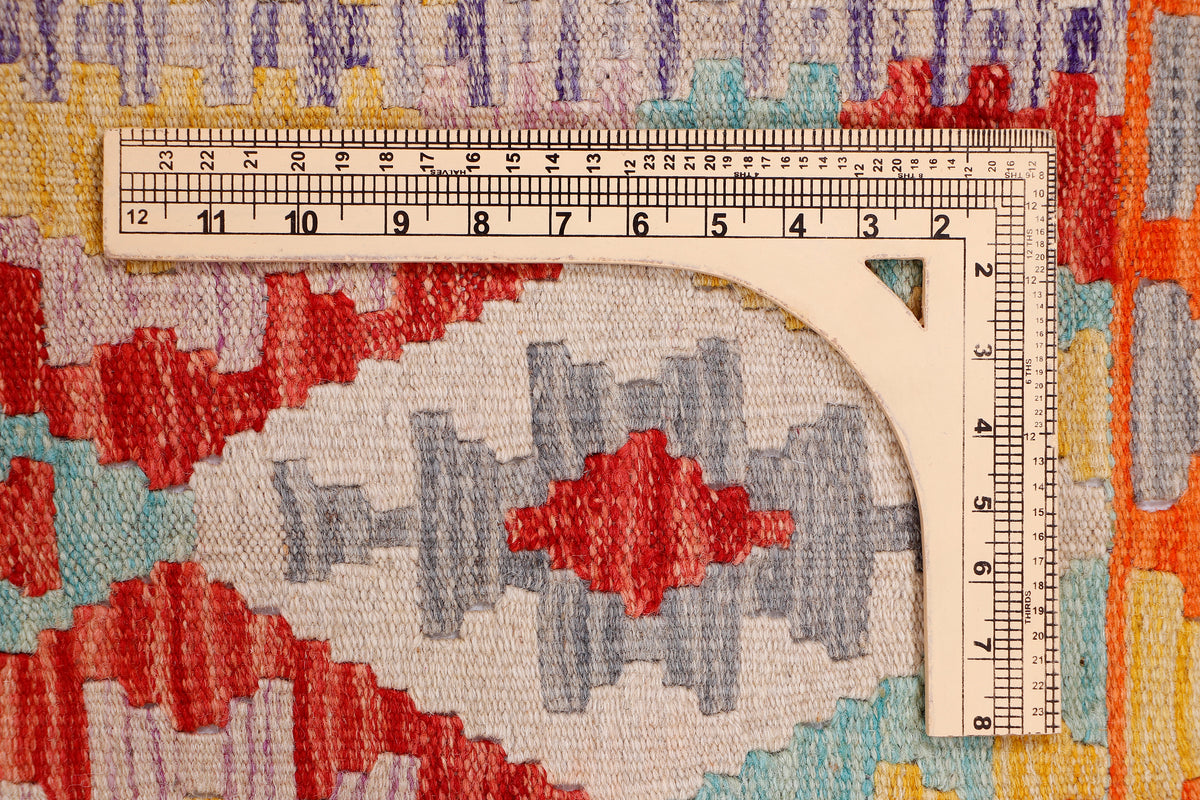 Geometric kilim rug section with orange, red, blue, and gray medallion pattern