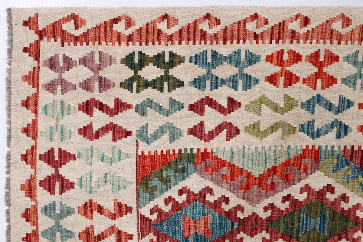 Kilim rug detail with red, teal, and cream cross-and-diamond motif