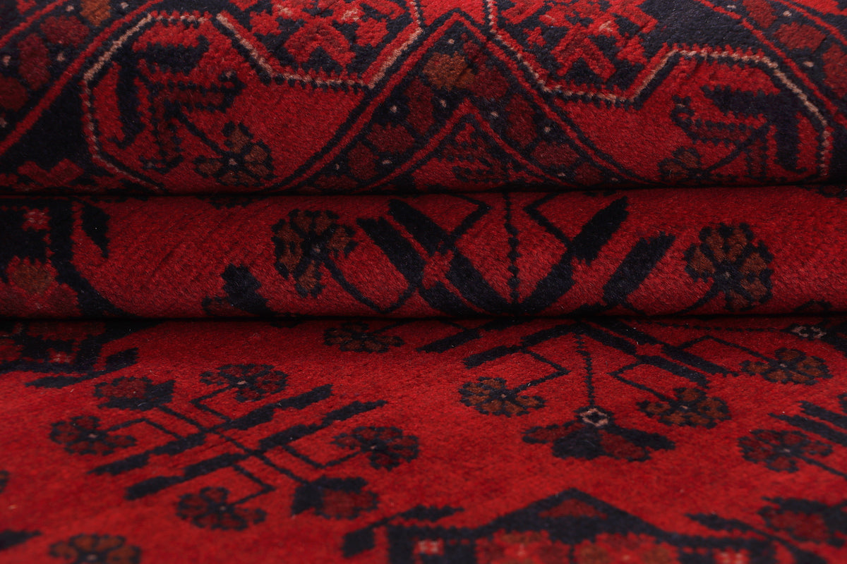 Red area rug with detailed geometric motifs and textured pile