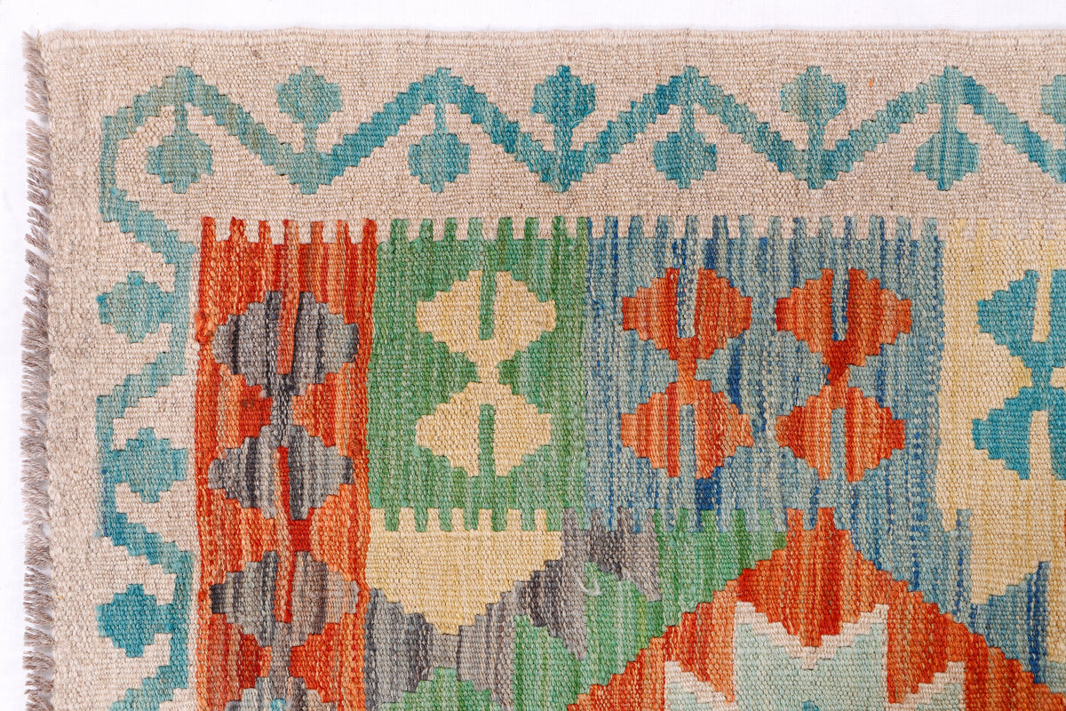 Flatweave area rug close-up with blue, green, and orange diamond pattern