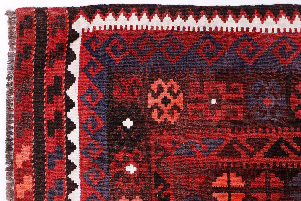 Red kilim rug section with blue-gray field, red motifs, and white accents