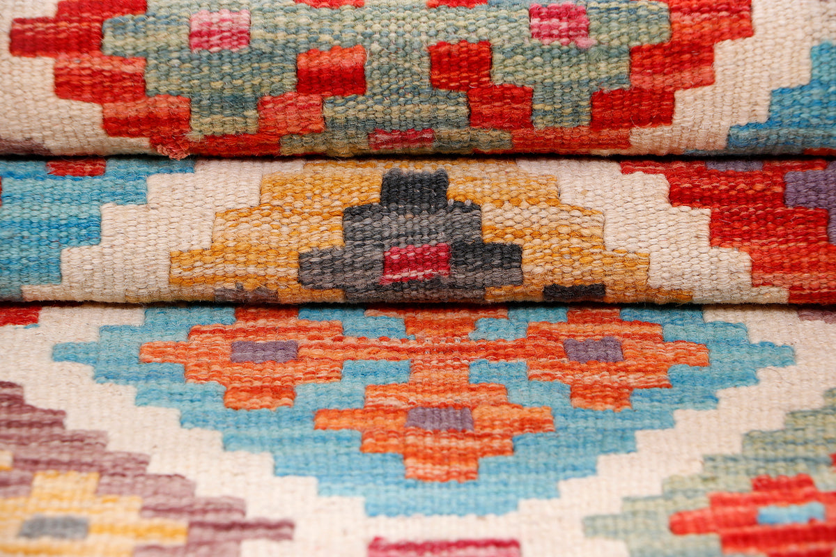 Kilim rug close-up with stacked diamond motifs in red, blue, and orange