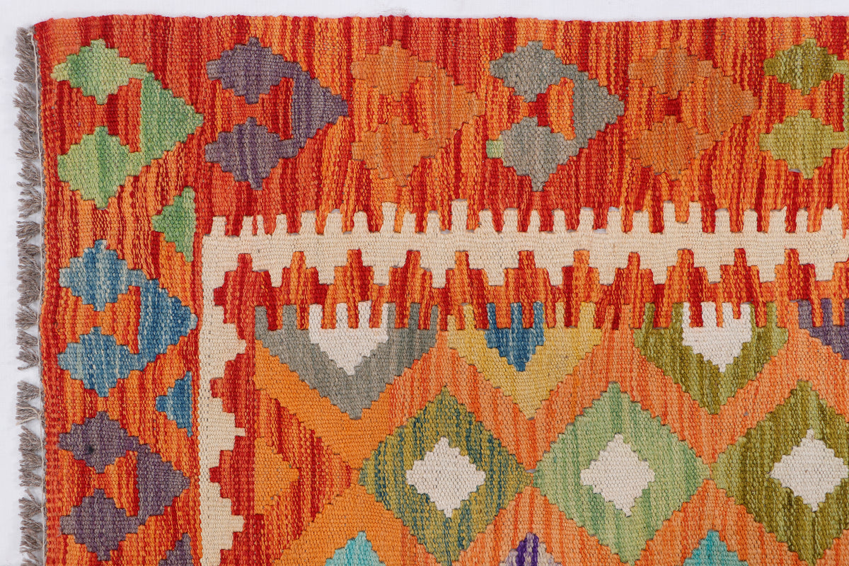 Orange kilim rug with diamond and geometric motifs, multicolor borders, woven texture