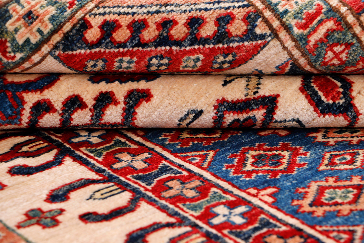 Blue Kazak rug close-up with red geometric motifs and textured pile