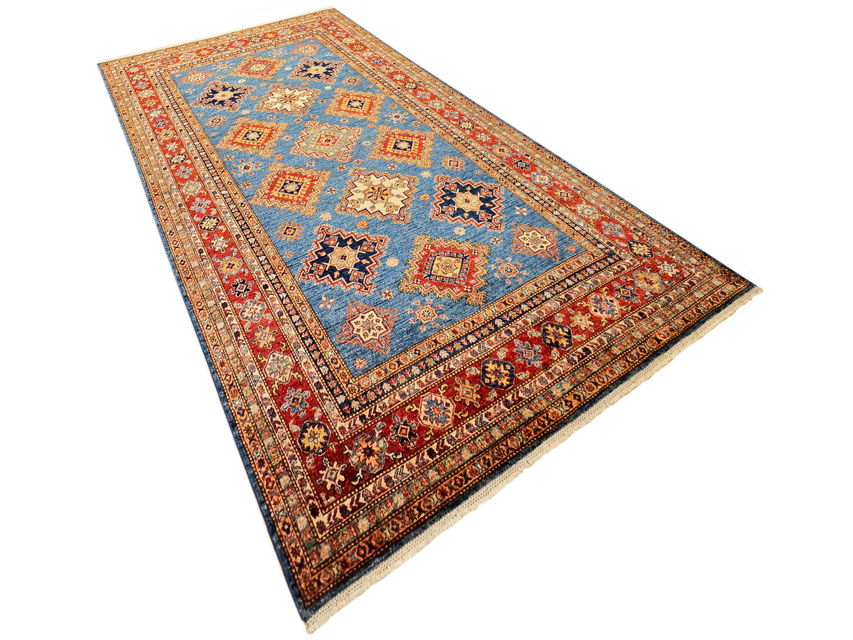 Geometric blue area rug with red frame border and multicolor cross motifs.