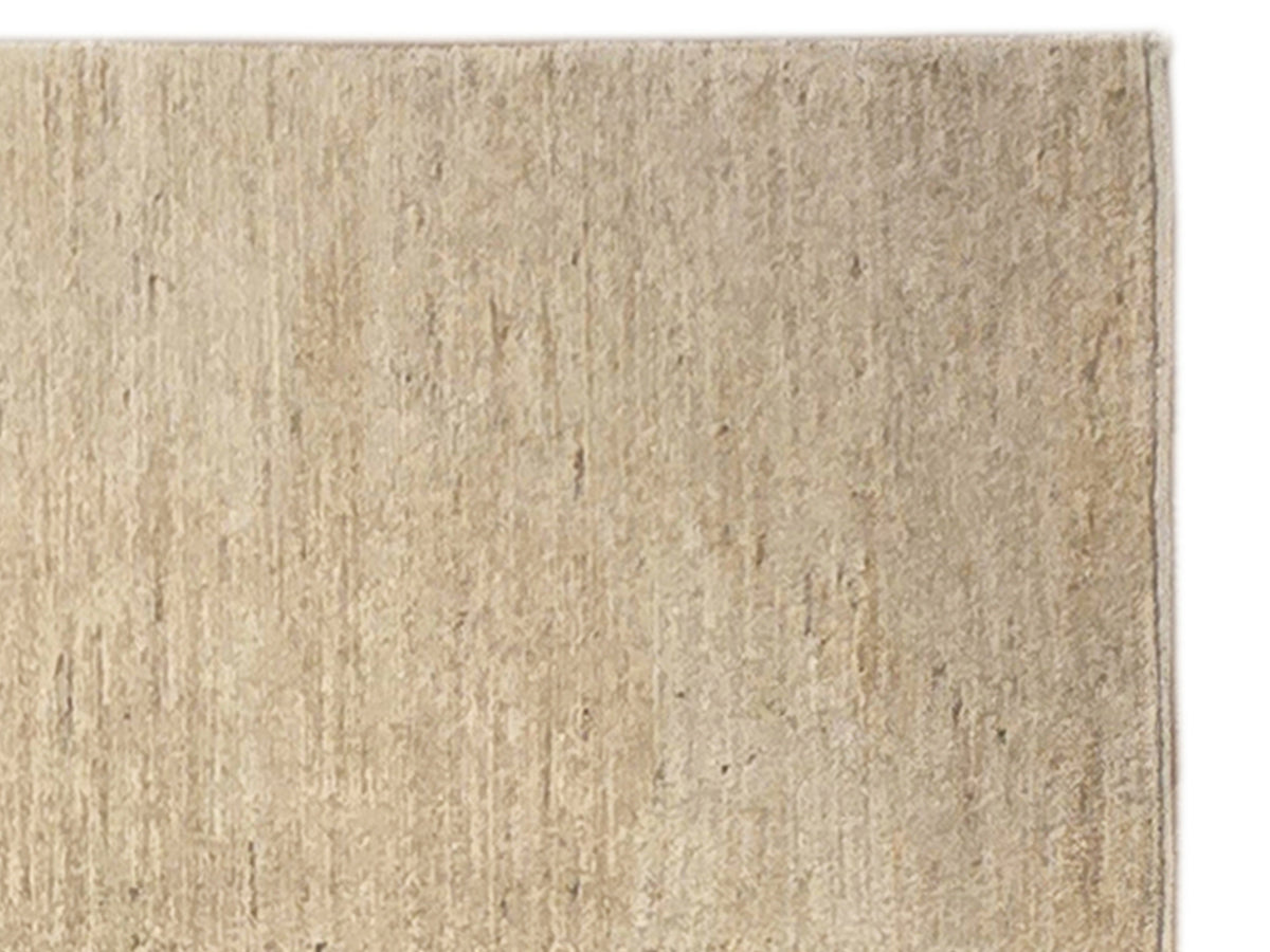 Beige rug close-up showing dense flat weave and mottled texture