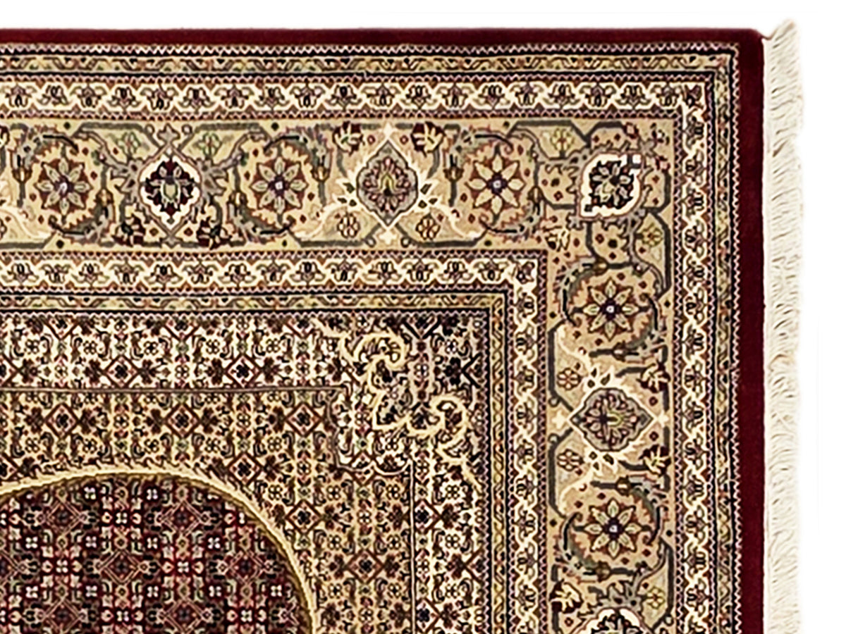 Patterned area rug border detail with small motifs and cream fringe trim