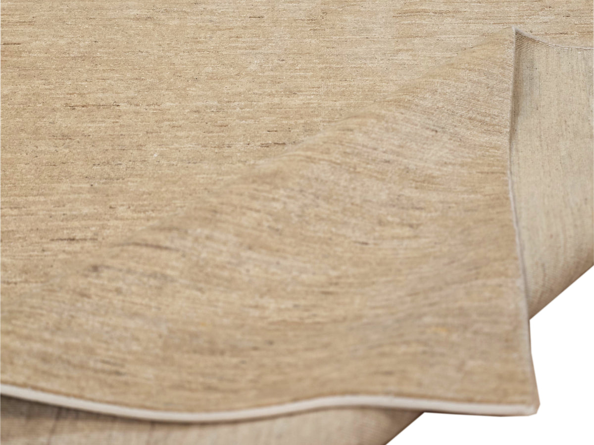 Beige rug edge detail with low-pile texture and neatly bound border