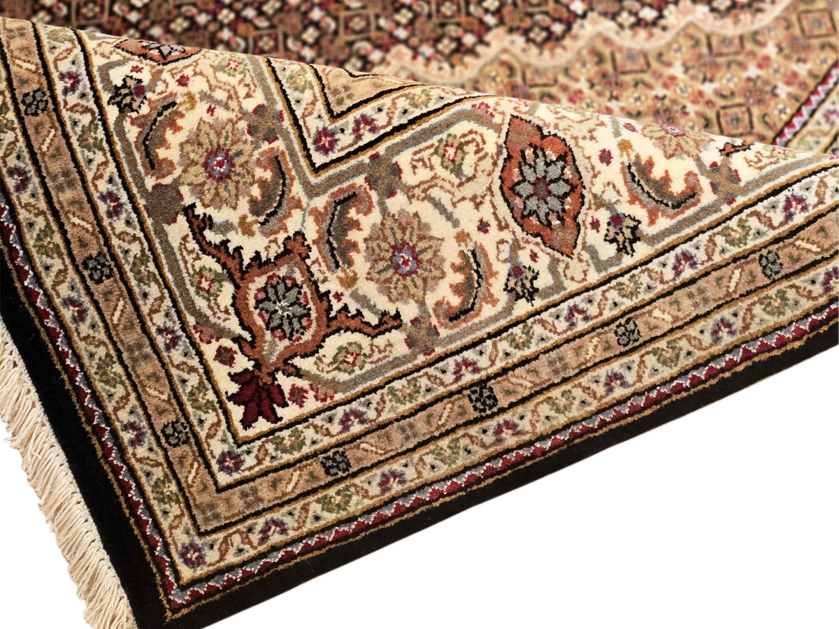 Floral Tabriz mahi rug with cream ground, dark accents, and detailed vine border
