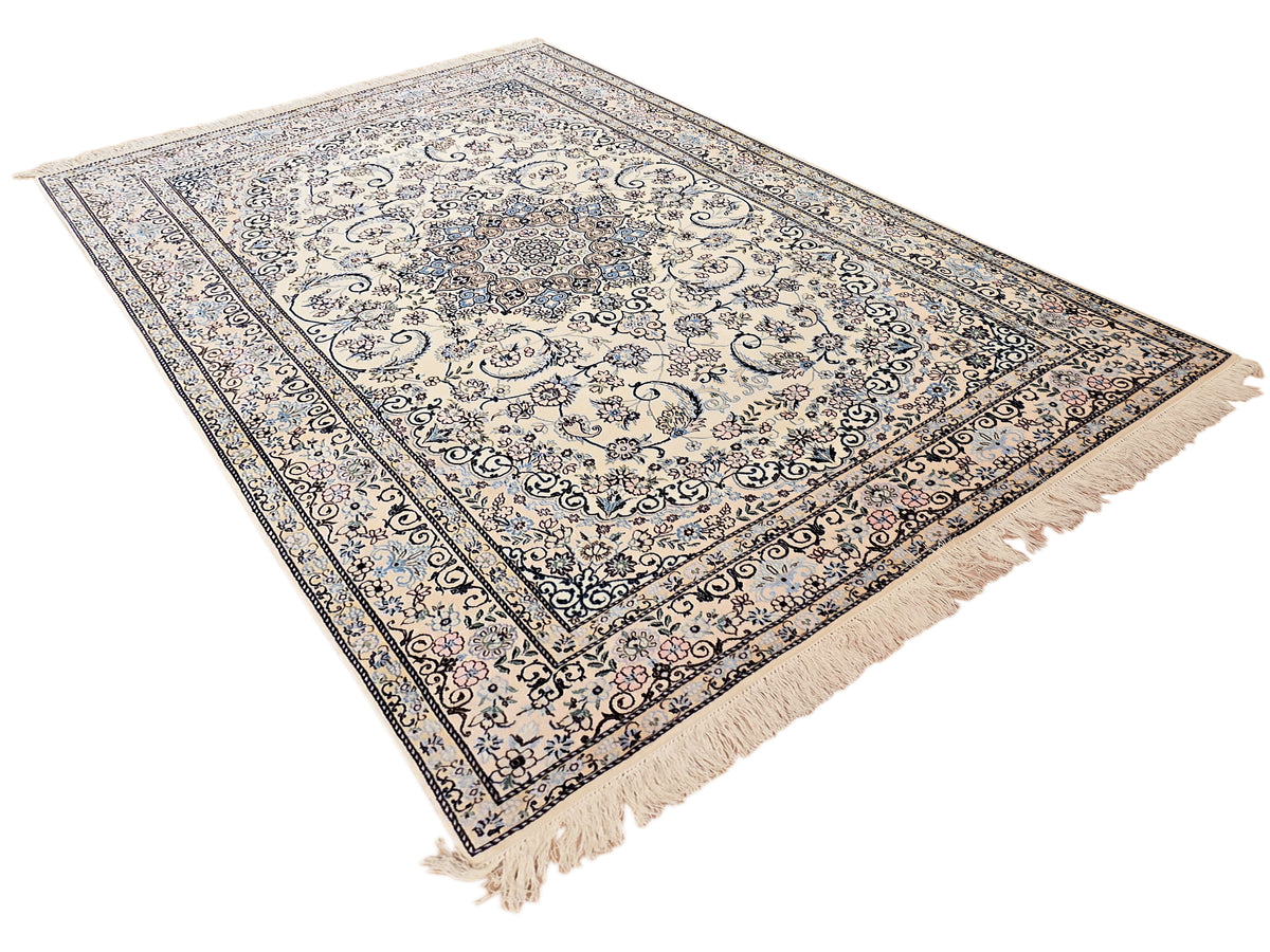 Rectangular area rug with cream base, blue and pink filigree patterns and fringe