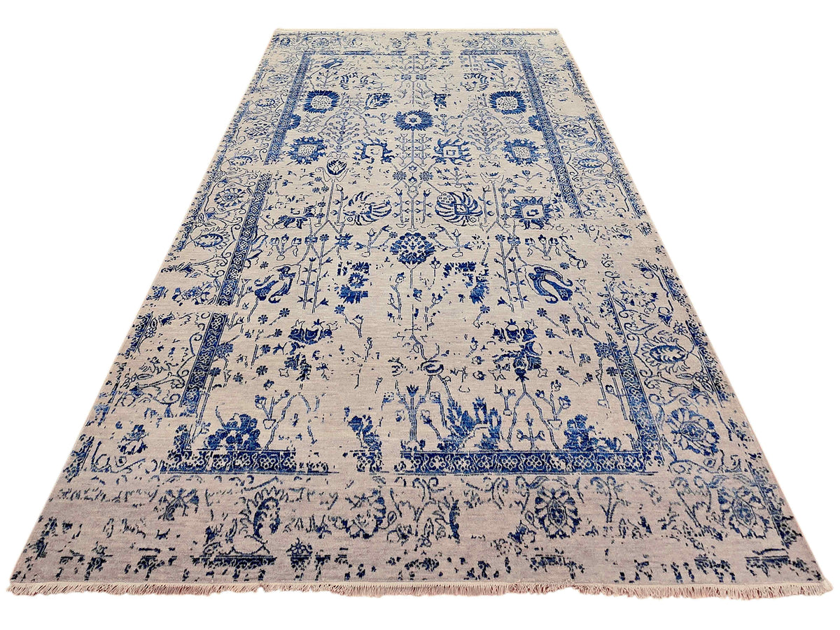 Cream rug with blue central medallion and decorative border, fringed ends