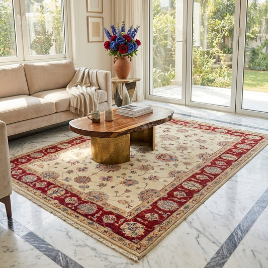 Traditional area rug in living room setting with cream field and red decorative border