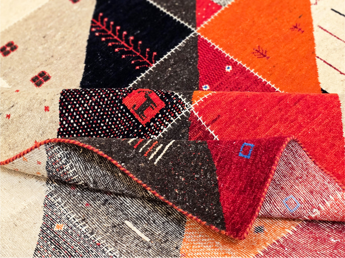 Close-up rug corner showing patchwork triangles and a red stitched edge