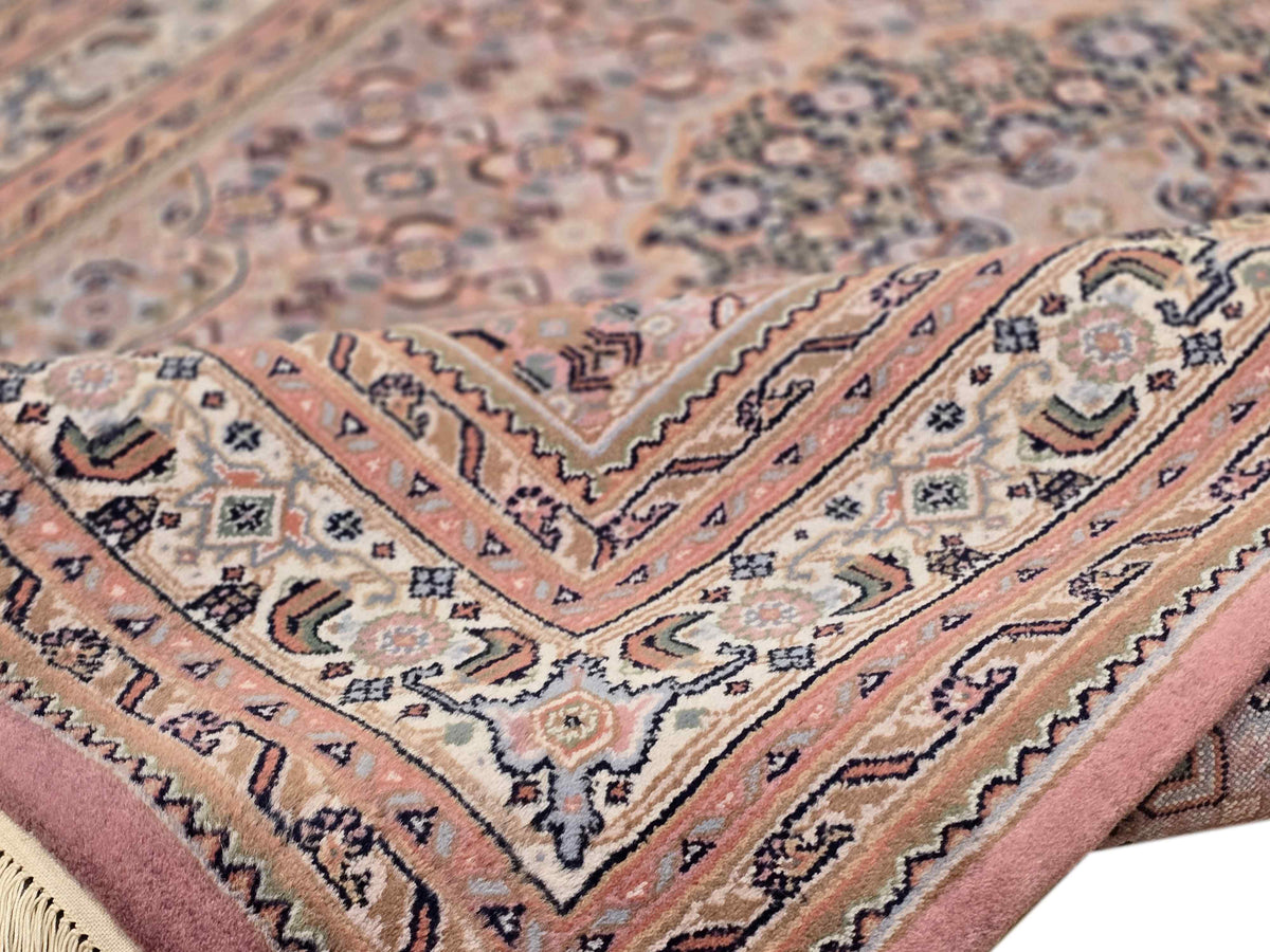 Close-up of Bidjar rug motifs with dusty rose, beige, and blue detail along border