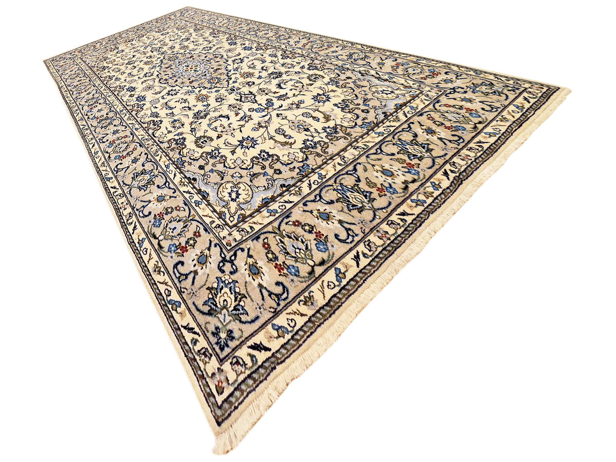Kashan-style area rug with blue floral pattern, dark border, and small red accents