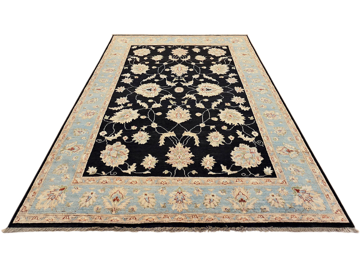Large rug with black floral center and light blue border with decorative corner details