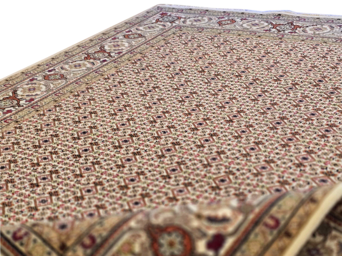 Beige rug close-up with dense micro-pattern texture and red-brown accents
