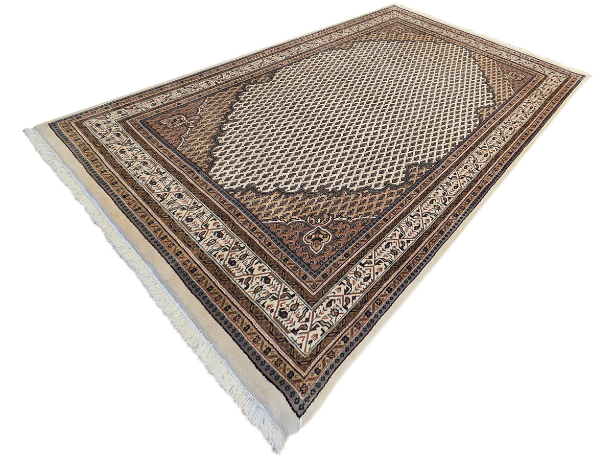 Square area rug with dark medallion center, ornate border, and light fringed edge