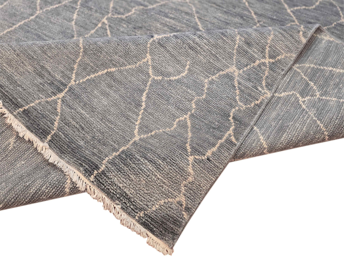 Rug corner detail in grey with crackled lattice pattern, light beige lines, fringes.