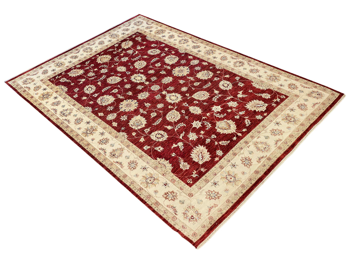 Red floral area rug with cream border and ornate corner motifs