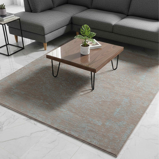 Modern area rug in room setting with distressed tan base and muted blue abstract motifs