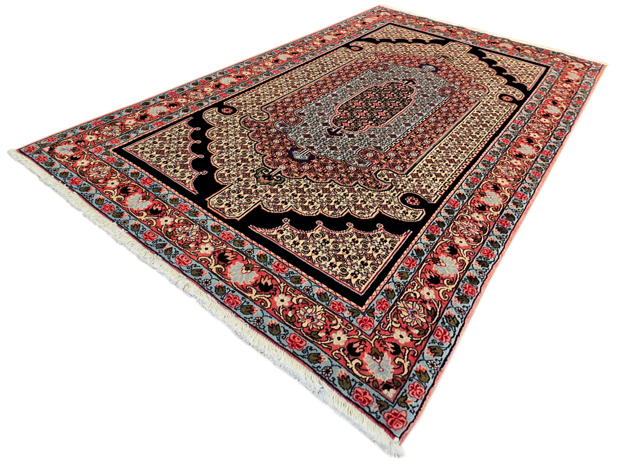 Ornate rectangular area rug with central medallion in red, navy, and cream tones.