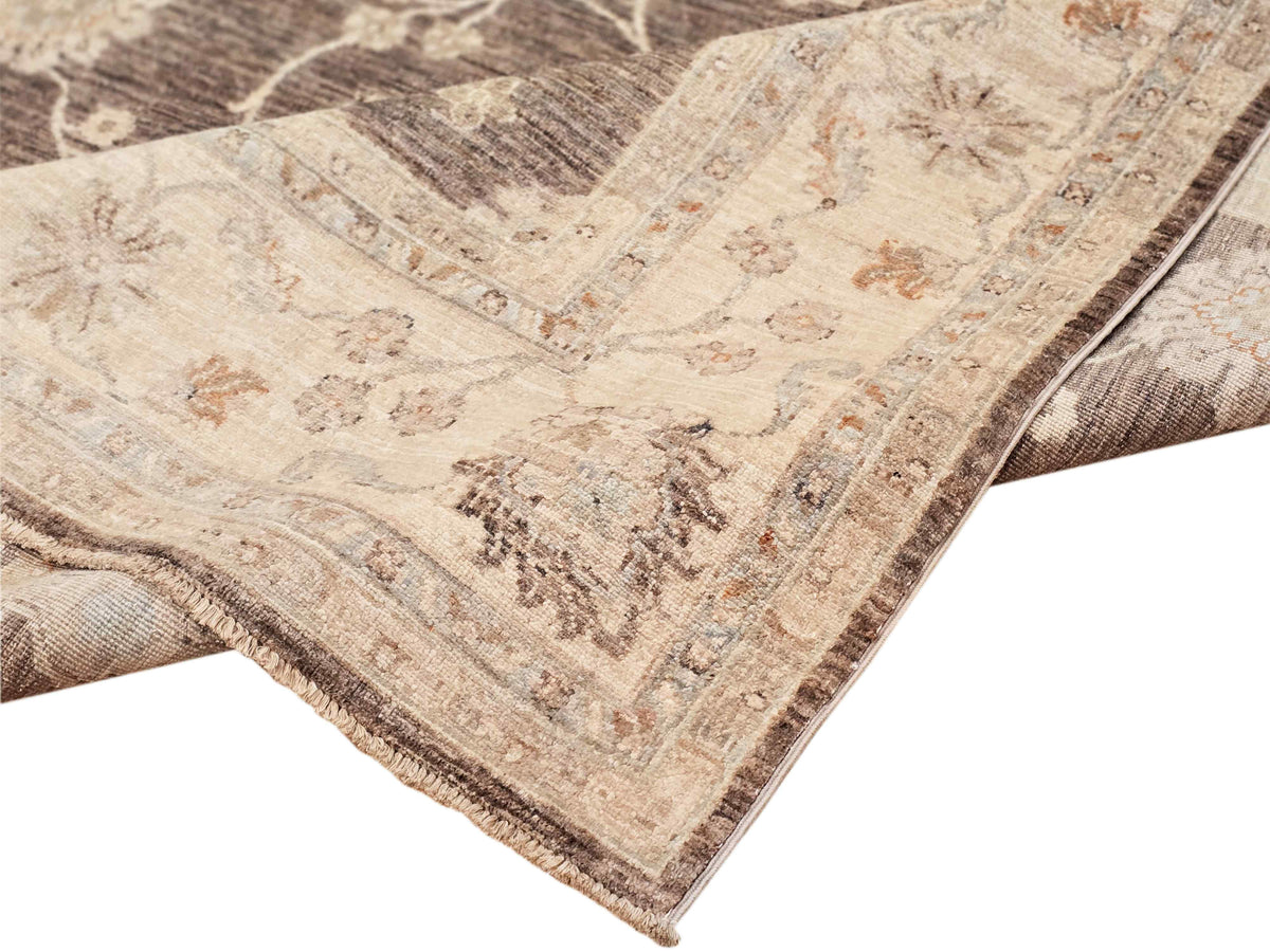 Afghan rug corner detail in beige and dark brown with trimmed border and fringe