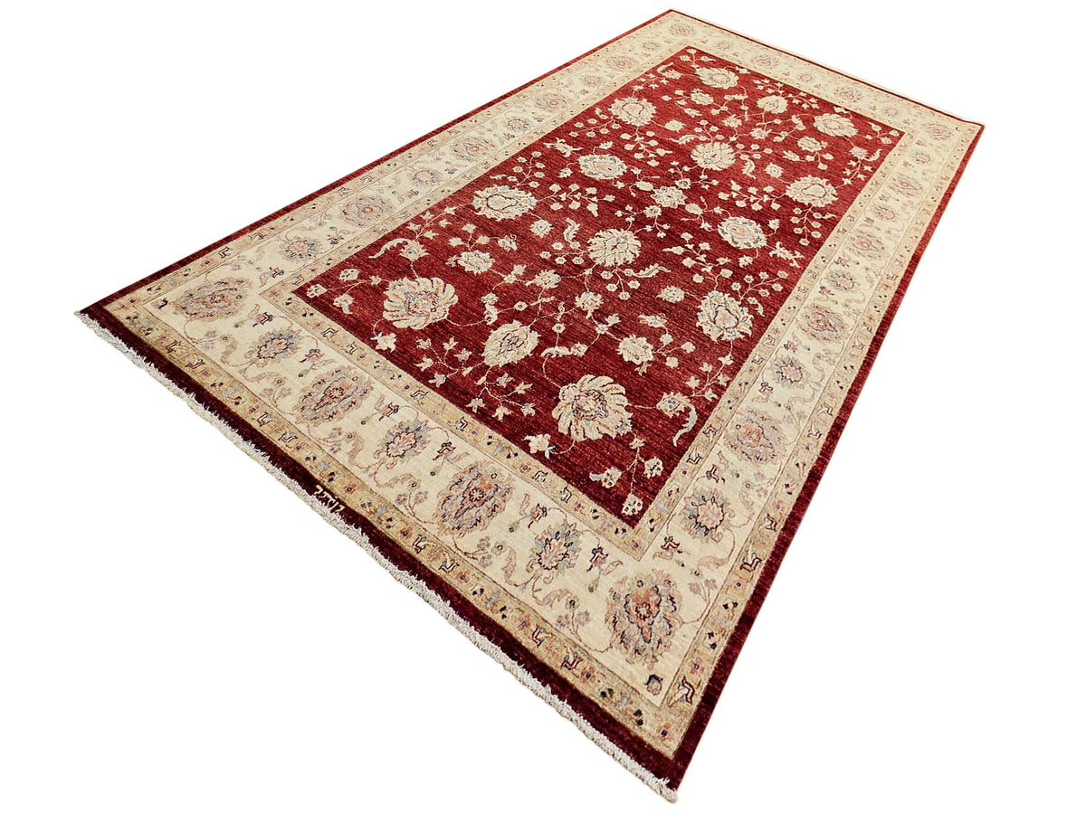 Red central field rug with cream border, detailed floral rosettes, rectangular