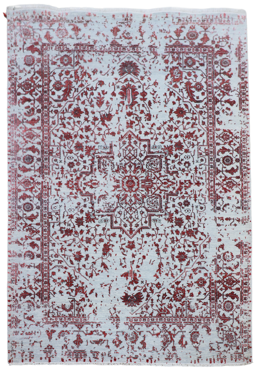 Light gray rectangular area rug with symmetrical red pattern and decorative border