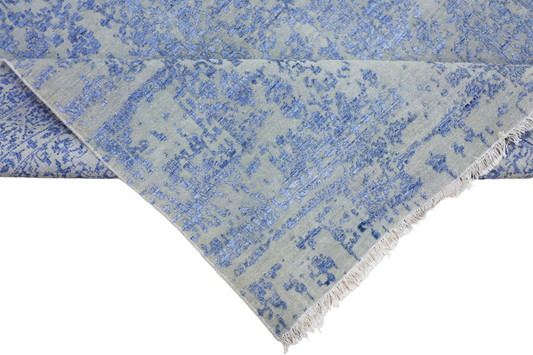 Blue mist rug with distressed allover pattern and short fringed corner edge.