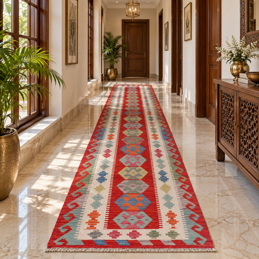 Kilim runner rug in red, cream, blue, and green geometric pattern laid along a hallway
