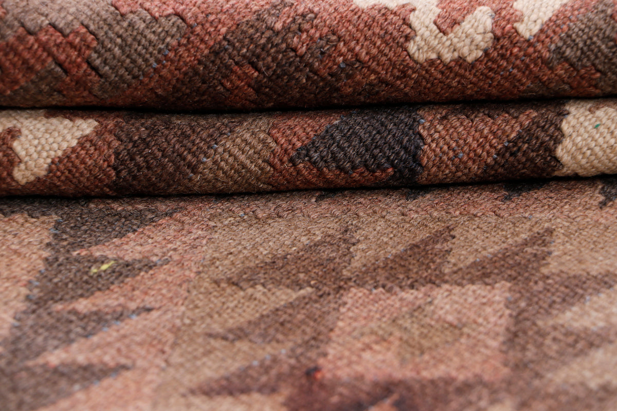 Brown kilim rug texture close-up with tightly woven pattern and folded edge