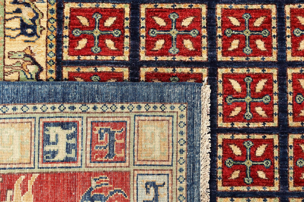 Rug corner detail with navy, red, and cream squares and decorative edging