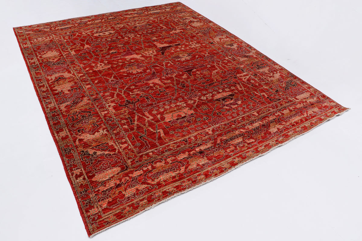 Red vintage rug laid diagonally, showing detailed pattern and decorative border.