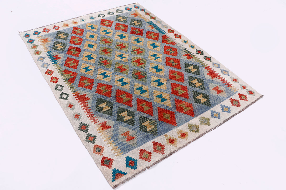 Kilim rug laid flat with multicolor diamond and cross motifs on cream