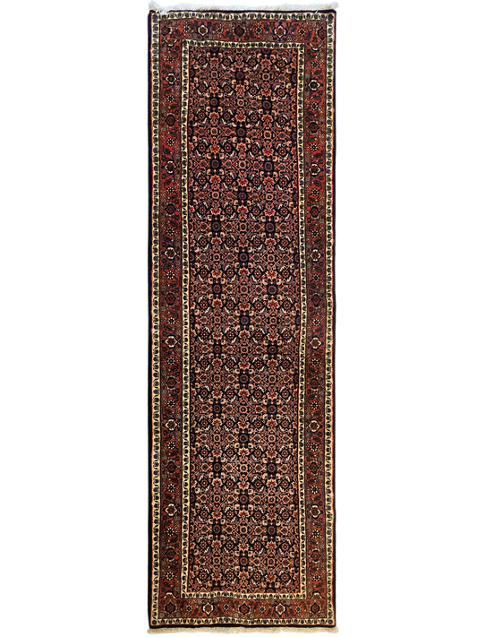 Bidjar rug with dark red central pattern, narrow side borders, and thin dark fringe.