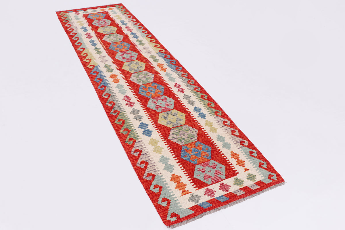 Kilim runner rug with diagonal layout in red, cream, blue, and green geometric blocks
