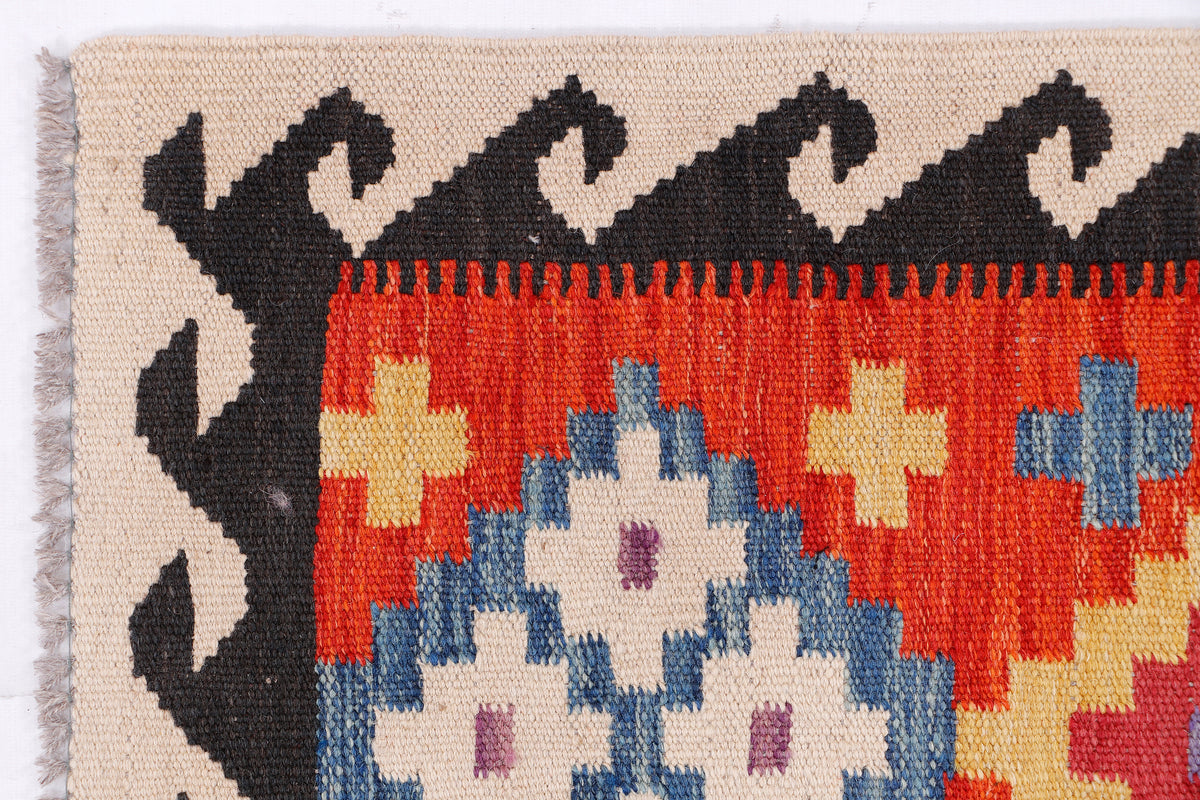 Red, blue & cream kilim rug with black zigzag border and fringe, geometric blocks