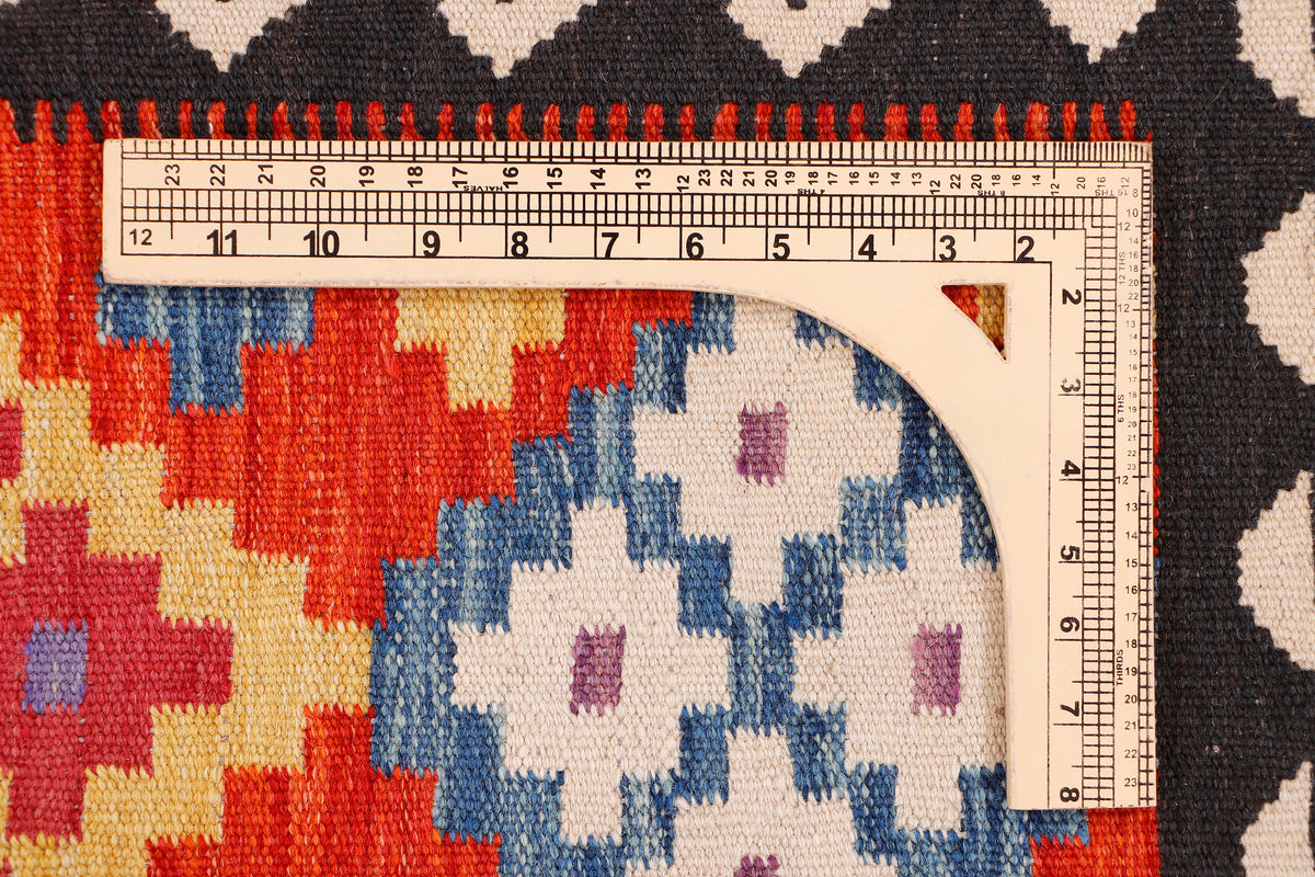 Kilim rug section with red, blue, and cream pattern, black border, with ruler