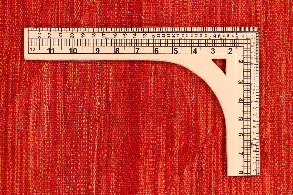 Red rug with corner seam and measuring ruler along the edge