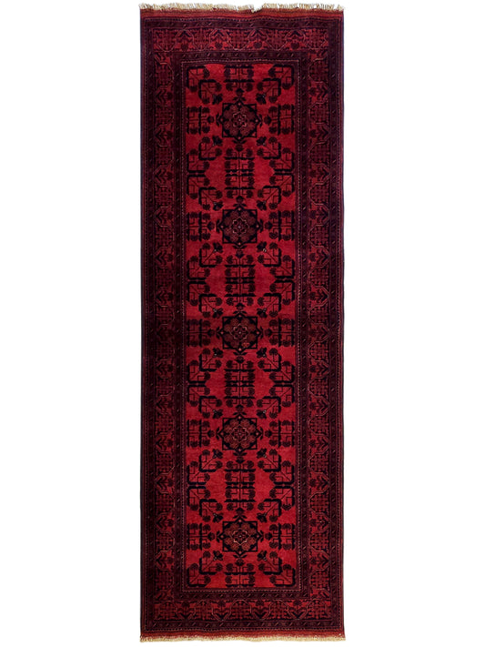Khanmohamad rug with deep red field, dark geometric motifs, and fringed edges.