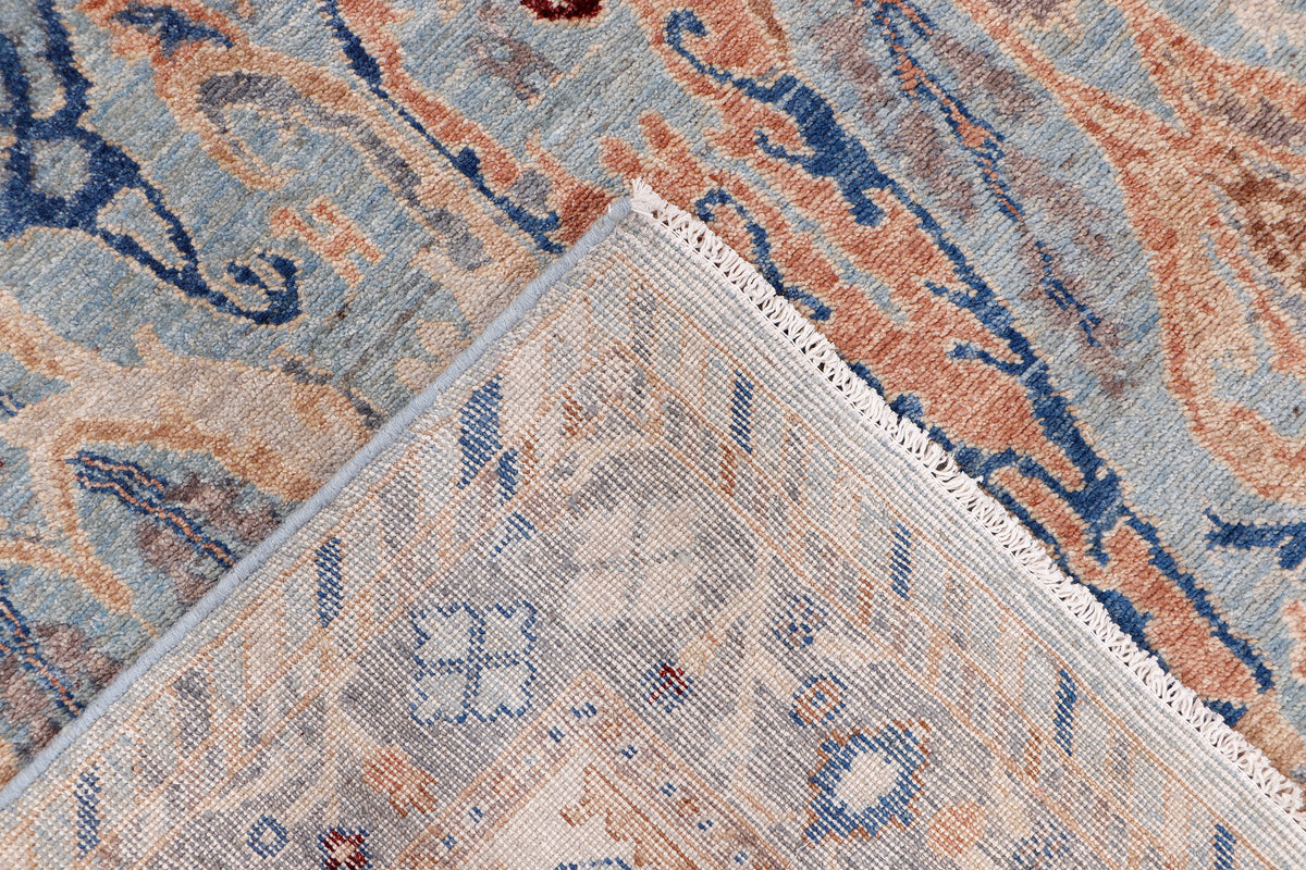 Blue Khyber Oushak rug, light blue with rust and navy pattern, close-up weave